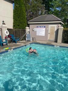 a woman laying on a frisbee in a swimming pool at Quality Inn & Suites in Dawsonville