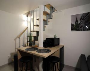 eine Küche mit einer Theke mit Hockern und einer Mikrowelle in der Unterkunft duplex chaleureux avec spa privé in Straßburg