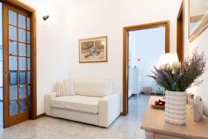 a living room with a white chair and a table at Godi Fiorenza Suite - Duomo a 15 Minuti e Aeroporto a 4 Minuti con Tramvia T2 in Florence +35 photos
