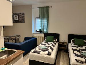 a living room with two beds and a sink at LENASTAY I City Comfort Apartment in Top Location in Kaiserslautern