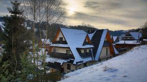 een huis met zonnepanelen op het dak in de sneeuw bij Aga in Suche