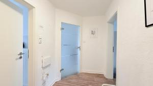 a hallway with a blue door in a room at Neumünster Apartments direkt an der Stadthalle mit WLAN & Parkplatz in Neumünster