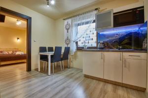 een keuken met een aquarium en een tafel en stoelen bij Aga in Suche