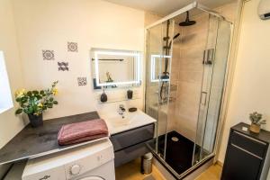 une salle de bain avec douche et lavabo dans l'établissement Maison familiale Terrasse Jacuzzi Parking sur place près d'Honfleur, à Équemauville