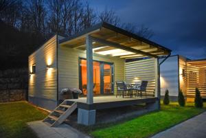 a small house with a deck with a table and chairs at Kub Grand View in Slănic-Moldova