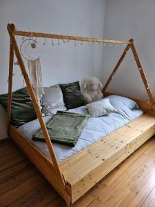 a wooden bed with a teddy bear sitting on it at Bienvenue chez Angèle Homes 1 in Niederbronn-les-Bains