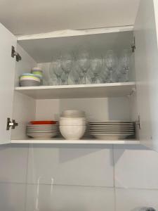 a shelf with wine glasses and plates on it at Departamento Fortaleza Boggiani in Asuncion