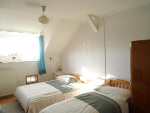 a bedroom with two beds and a window at Garden Szivárvány utca 39 Superior Vendégház in Szeged