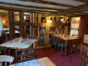 a restaurant with wooden walls and tables and chairs at The Red Cow Pub Chrishall Ltd in Heydon