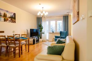 salon z kanapą i stołem w obiekcie Apartament Deluxe w mieście Płock