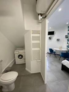 a bathroom with a toilet and a kitchen with a table at Cozy studio 3min MER nice CENTRE in Nice