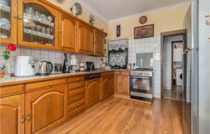 a large kitchen with wooden cabinets and wooden floors at Stunning Apartment In Kostrena in Kostrena