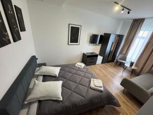 a bedroom with a bed and a couch and a chair at Pensiunea Luisa in Craiova