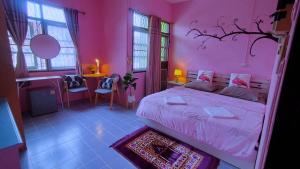 a pink bedroom with a bed and a desk at Ruenthip Homestay in Bangkok +110 photos