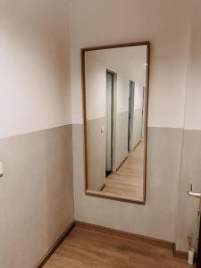 einen Spiegel an einer Wand in einem Zimmer mit Flur in der Unterkunft Wohnen im Ländereck Essen Mülheim Oberhausen BS1HL in Essen