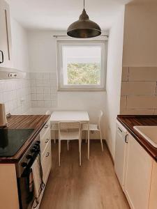 eine kleine Küche mit Tisch und Fenster in der Unterkunft Wohnen im Ländereck Essen Mülheim Oberhausen BS1HL in Essen