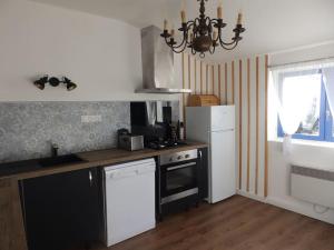 a kitchen with a white refrigerator and a stove at Maison des oiseaux in Menou +12 photos