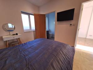 a bedroom with a bed with a television and a mirror at The Lodge at The Elms in Keynsham +9 photos