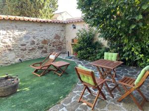 une terrasse avec trois chaises, une table et une table avec des chaises dans l'établissement Casa del Maestro, à Paradinas