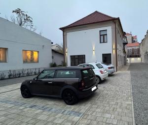 奥拉迪亚Ullmann Residence cu parcare in curte的停在大楼旁边的一辆黑色小汽车