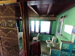 a bathroom with two toilets and a green wall at Lindo casarão assobradado no centro de Itaúnas in Conceição da Barra