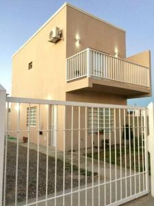a fence in front of a house with a balcony at Moana II in Las Grutas