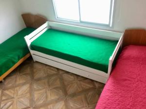 a room with two beds and a green mattress at Moana II in Las Grutas