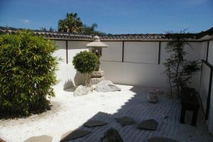 a backyard with a white wall and a stone walkway at La Luna Blanca in Torremolinos