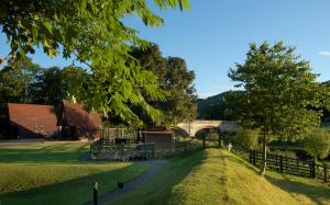a park with a bridge and trees and a fence at River Edge Lodges in Perth