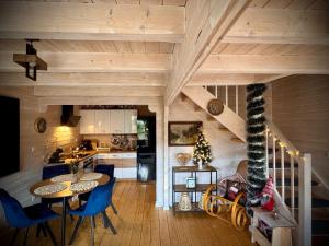 a kitchen and living room with a table and chairs at Śnieżna Chatka - Sosnówka Karpacz in Sosnówka