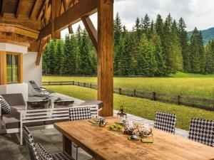 een tafel en stoelen op een patio met uitzicht op een veld bij Chalet Märchenblick in Leutasch
