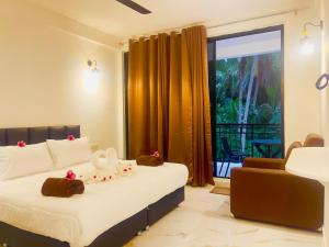 a hotel room with a bed and a balcony at Sunnyside Inn Thoddoo in Thoddoo