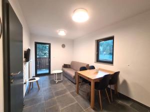 a living room with a table and a couch at Alpine Escape Golte Apartment in Mozirje