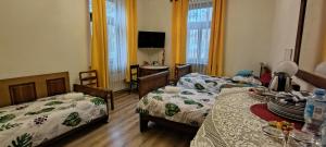 a room with two beds and a table with a tv at Kasztelania Pod Lipami in Zakroczym