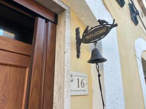 a welcome sign on the side of a building with a bell at Sangro River Casa Vacanza in Castel di Sangro