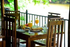 a table with a plate of food and two glasses of orange juice at VIP Karaoke Lounge in Peradeniya