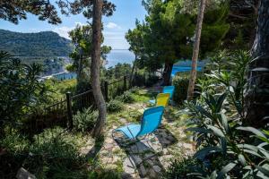 two blue and yellow chairs sitting on the side of a path at Villa Degenija - Principality of Zarijak in Jablanac +44 photos