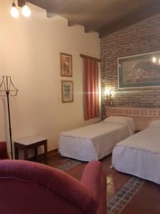 a hotel room with two beds and a couch at La Pink House Salta, Monoambiente amplio y cómodo in Salta