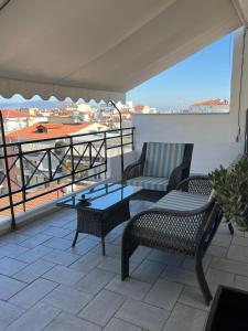 balcón con 2 sillas, mesa y sofá en 19 Αri, en Tríkala