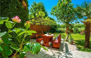a garden with a table and a bench and a rose at Adorata 1 in Labin