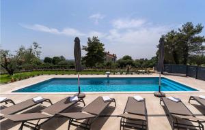 eine Gruppe von Stühlen und Sonnenschirmen neben einem Pool in der Unterkunft Villa Gloria in Frata