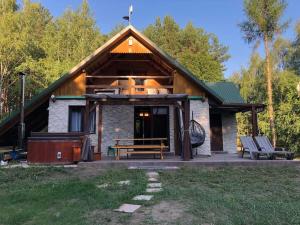 a log cabin with a bench and a picnic table at Zacisze leśne w Juliance in Grady Szlacheckie