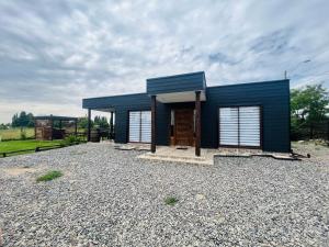a blue tiny house on a gravel lot at LETICE LODGE Chillán in Chillán