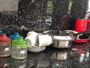 a kitchen counter with dishes and a pan and water on it at Renu's House By Villa Greenery in Talpe