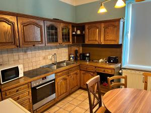 a kitchen with wooden cabinets and a table and a sink at Unterkunft Dähre in Dähre +32 photos