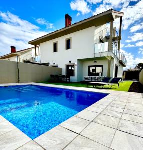 a house with a swimming pool in front of a house at Golf villa heated pool relax tenerife south in San Miguel de Abona
