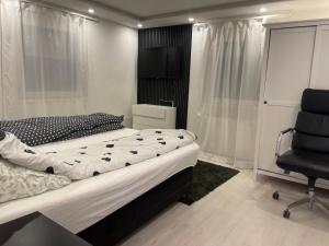a bedroom with a large bed and a chair at GraceHomes (Entry to Blackforest) in Jettingen +4 photos