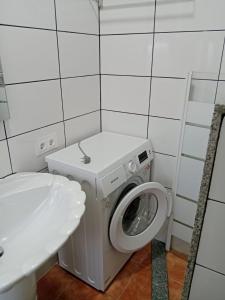 a bathroom with a washing machine and a toilet at Casa turística Lirio in Chandreja