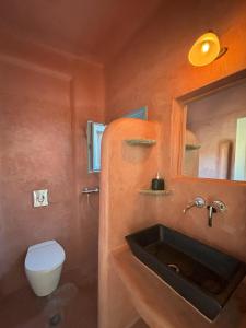 a bathroom with a sink and a toilet and a mirror at Almyra Yellow Villa in Kithnos +33 photos