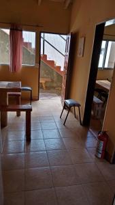 Zimmer mit einem Tisch und einer Bank auf einem Fliesenboden in der Unterkunft Los Milenarios in El Chalten